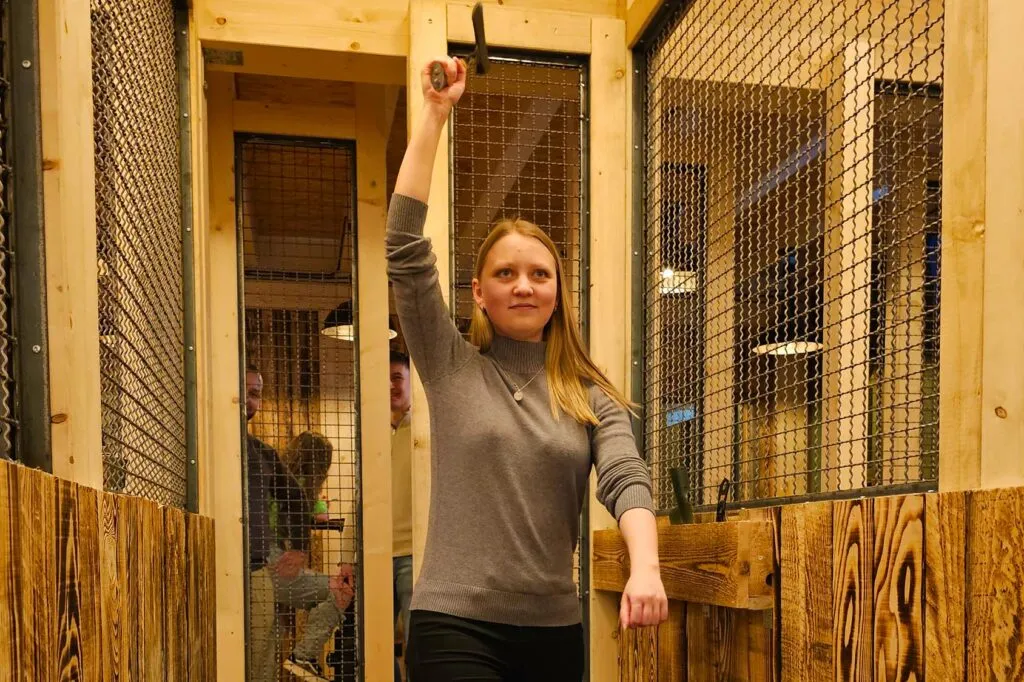 A group of friends at an axe-throwing venue, enjoying an activity together.